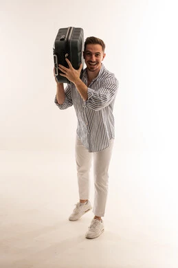 رجل سعودي يحمل حقيبة سفر في استوديو بخلفية بيضاء