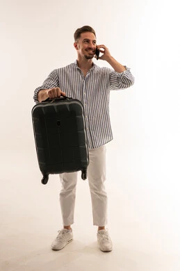 رجل سعودي مع حقيبة سفر يتحدث بالهاتف في الاستوديو