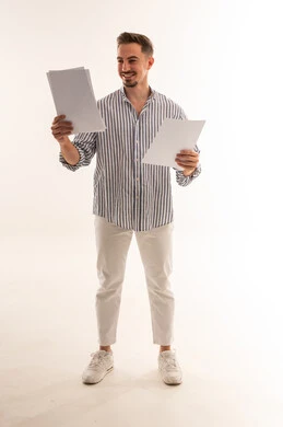 رجل سعودي يحمل أوراقاً أمام خلفية بيضاء