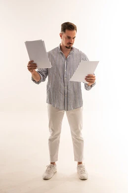 رجل سعودي يراجع مستندات وأوراق أمام خلفية بيضاء