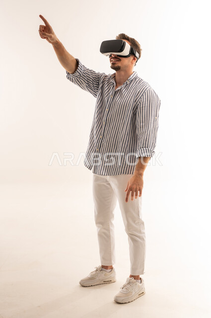 رجل سعودي يستخدم سماعة الواقع الافتراضي بخلفية بيضاء