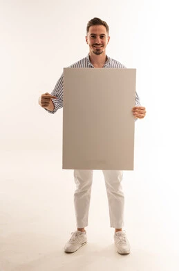 رجل سعودي يحمل لوحة بيضاء فارغة في استوديو