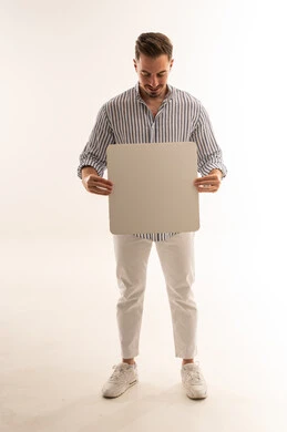 رجل سعودي يحمل لوحة بيضاء مربعة فارغة في الاستوديو