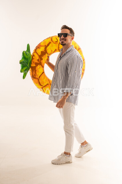 Saudi Man with Inflatable Pineapple Ring Summer Concept