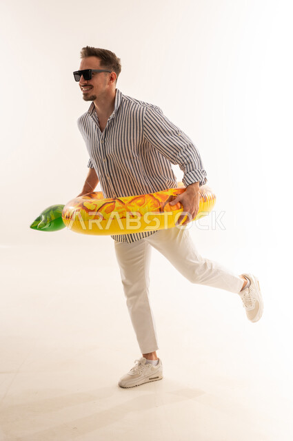 Saudi Man with Pineapple Swim Ring on White Background