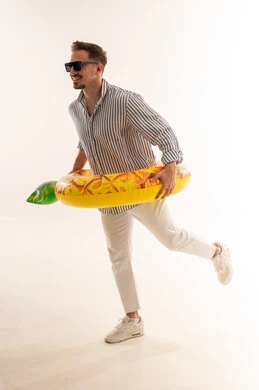 رجل سعودي مع طوق سباحة أناناس بخلفية بيضاء