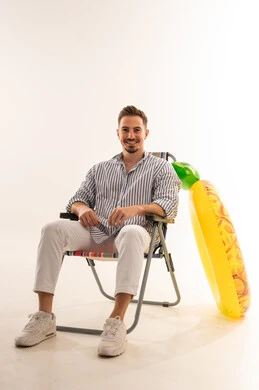 رجل سعودي مع عوامة أناناس على كرسي بحر