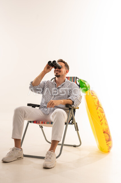 Saudi Man with Binoculars and Beach Chair