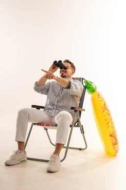 Saudi Man on Beach Chair with Binoculars and Inflatable