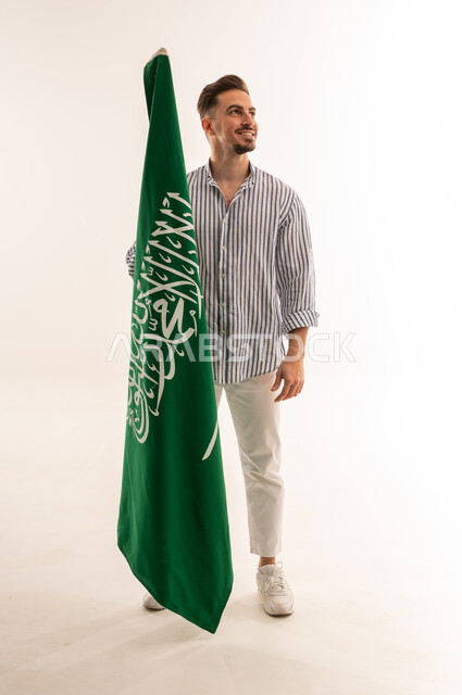 Saudi Man Holding Saudi Arabia Flag in White Studio
