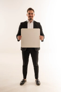 رجل أعمال سعودي يحمل لوحة بيضاء فارغة في الاستوديو
