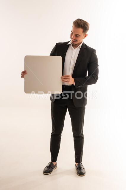 رجل أعمال سعودي يحمل لوحة بيضاء فارغة