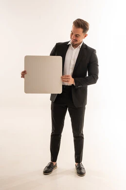 رجل أعمال سعودي يحمل لوحة بيضاء فارغة