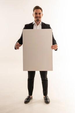 رجل سعودي يحمل لوحة بيضاء فارغة في الاستوديو