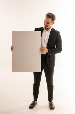 رجل أعمال سعودي يحمل لوحة إعلانية فارغة بخلفية بيضاء