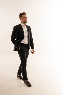 رجل أعمال سعودي بالبدلة الرسمية يمشي على خلفية بيضاء