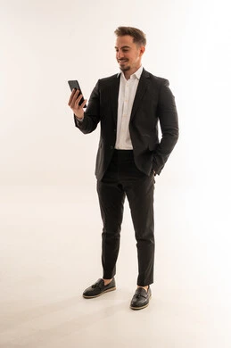 رجل أعمال سعودي ببدلة رسمية يستخدم الهاتف الذكي