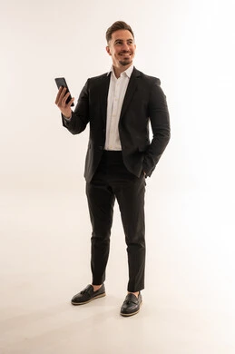 رجل أعمال سعودي مع هاتف ذكي في استوديو أبيض