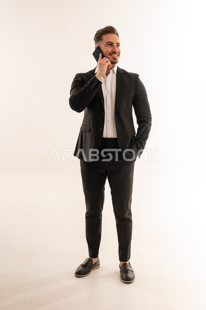 رجل أعمال سعودي ببدلة يتحدث عبر الهاتف المحمول