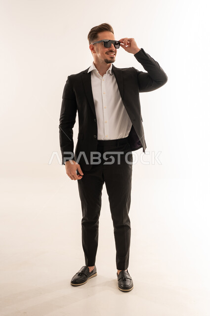 رجل سعودي ببدلة سوداء ونظارات شمسية