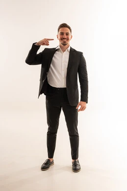 رجل أعمال سعودي يشير بيده ببدلة رسمية سوداء