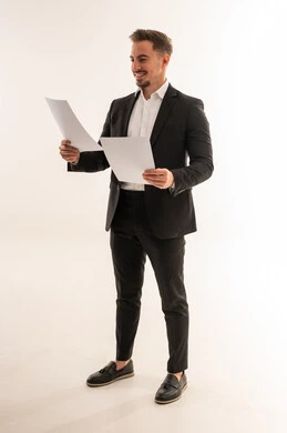 رجل أعمال سعودي يمسك أوراقاً بخلفية بيضاء