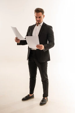 رجل أعمال سعودي يراجع مستندات على خلفية بيضاء