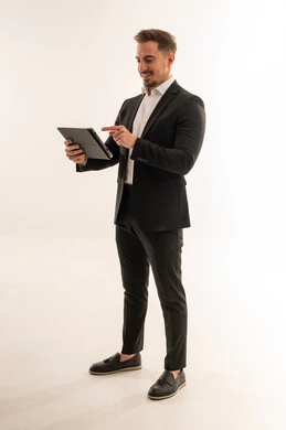 رجل أعمال سعودي يرتدي بدلة سوداء ويستخدم تابلت