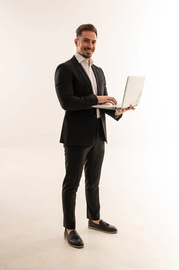 رجل أعمال سعودي يحمل لاب توب بخلفية بيضاء
