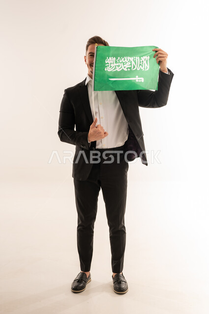 رجل سعودي يحمل العلم الوطني في الاستوديو
