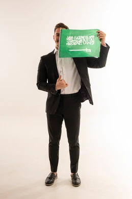رجل سعودي يحمل العلم الوطني في الاستوديو