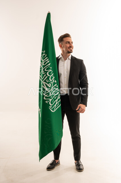 Saudi Man in Suit Standing Beside the Saudi National Flag
