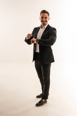 رجل أعمال سعودي بالبدلة يتفقد ساعته الذكية في الاستوديو