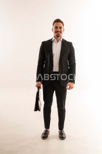 رجل أعمال سعودي يحمل حقيبة عمل خلفية بيضاء