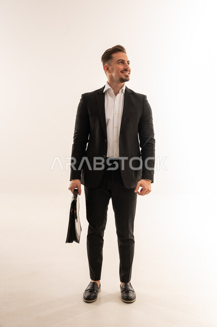 رجل أعمال سعودي يرتدي بدلة سوداء مع حقيبة عمل