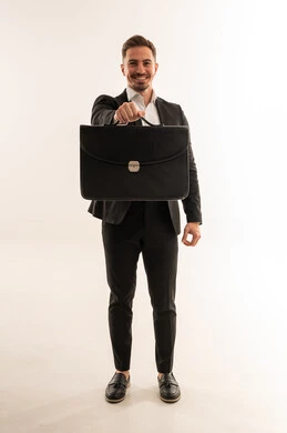 رجل أعمال سعودي يحمل حقيبة عمل على خلفية بيضاء