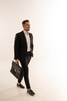 رجل أعمال سعودي يمشي مع حقيبة في الاستوديو