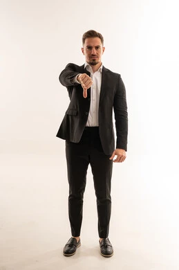 رجل أعمال سعودي يشير بعلامة عدم الإعجاب بخلفية بيضاء