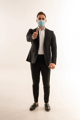 رجل أعمال سعودي يرتدي كمامة مع إشارة الإبهام