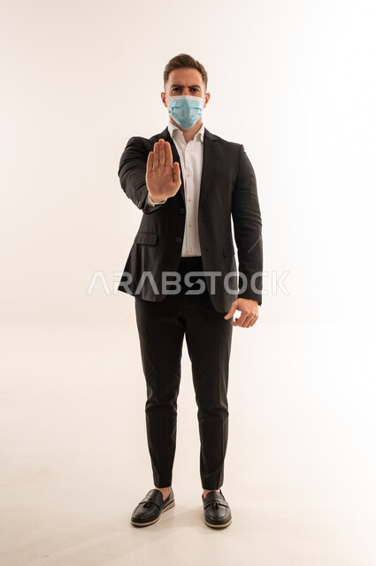 Saudi Businessman in Suit Wearing Mask Making Stop Sign