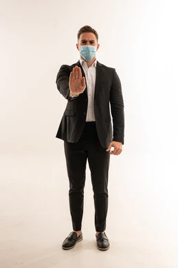 رجل أعمال سعودي بالبدلة والكمامة يقوم بإشارة التوقف