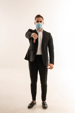 رجل أعمال سعودي يرتدي كمامة ويشير بعدم الموافقة