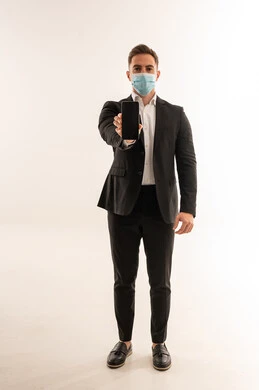 رجل أعمال سعودي بالكمامة يحمل هاتف ذكي خلفية بيضاء