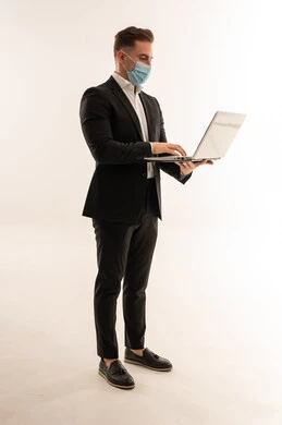 رجل أعمال سعودي بالكمامة يستخدم اللابتوب خلفية بيضاء