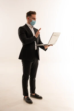 رجل أعمال سعودي بجهاز لابتوب وكمامة بخلفية بيضاء