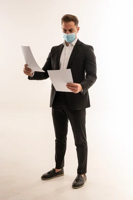 رجل أعمال سعودي بالكمامة يحمل أوراق في الاستوديو