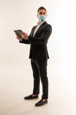 رجل أعمال سعودي بالبدلة والكمامة يمسك تابلت