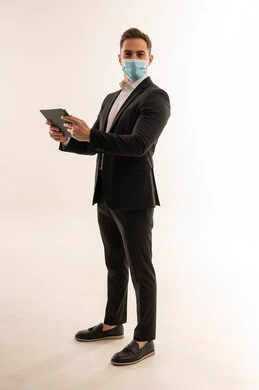 رجل أعمال سعودي يرتدي كمامة مع جهاز لوحي