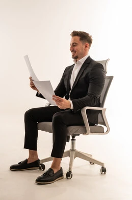 رجل أعمال سعودي يرتدي بدلة يقرأ مستندات في استوديو