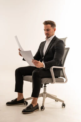 رجل أعمال سعودي يراجع مستندات على كرسي مكتب